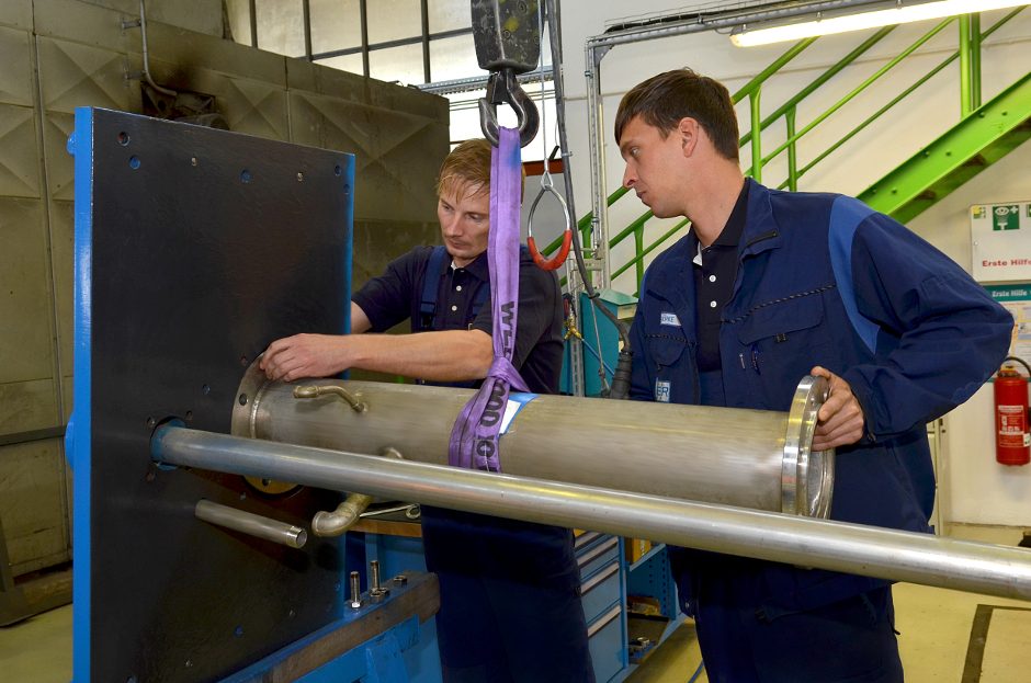 Deux techniciens Egger examinant une pompe dans un atelier